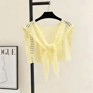 Close-up detail of hollow-out knit shawl, lightweight hollow pattern, tie-front design.