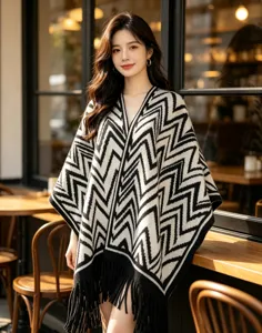 Poncho in maglia con motivo chevron bianco e nero, elegante scialle mantella con frange donna.