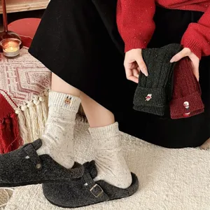 Cozy winter wool Christmas socks with cute embroidered cuffs and speckled yarn design.