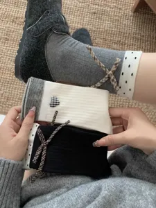 Detail view of women cotton mid tube socks featuring cute heart and plaid bow design.