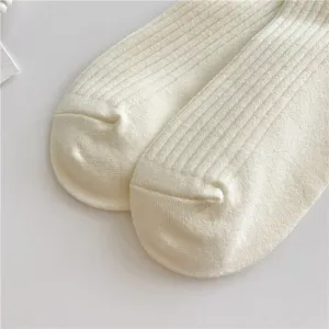 Primo piano di calze a costine in cashmere tinta unita, consistenza morbida e calda.