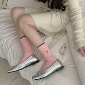 Korean style pink crew socks with cute bow embroidery detail paired with silver ballet flats.