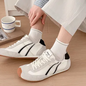 Calzini casual bianchi da uomo abbinati a scarpe da ginnastica, in cotone traspirante.