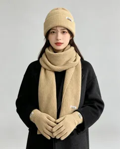 Cozy winter knit set detail showing ribbed beanie hat, matching scarf, and touchscreen gloves.