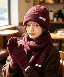 Close up detail of women winter burgundy knitted beanie hat scarf and gloves set for cozy daily wear.