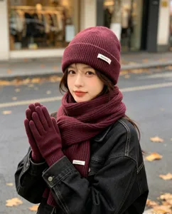 Winter three-piece knitted hat scarf and gloves set for women in dark red color detail view.