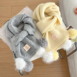 Cozy winter knitted scarf with cute plush pom-poms for women, warm and stylish neck warmer.