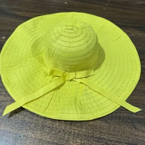 Vue détaillée du chapeau de soleil jaune à large bord, protection de plage pliable.