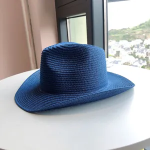 Vista detallada de un sombrero de cowboy de paja azul con ala clásica para la playa.