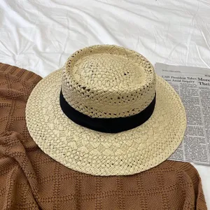 Chapeau de paille élégant pour femmes avec ruban noir pour vacances à la plage et protection solaire.