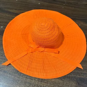 Vue rapprochée du chapeau de soleil orange vif avec un joli ruban nœud élégant.