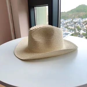 Vista detallada del sombrero de paja beige estilo western, ala enrollada, proteccion solar.