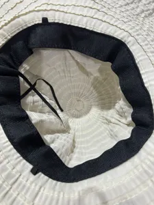 Vue détaillée de la structure intérieure d'un chapeau de soleil pour femme à large bord noir.