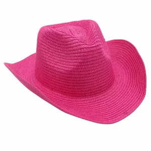 Detalle de sombrero de paja vaquero rosa, sombrero de sol tejido para la playa.