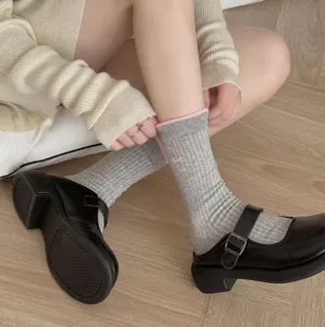 Detailed shot of Korean style grey ribbed socks with pink bow embroidery and cute trim.