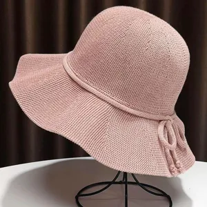 Pink knitted bucket hat for women, stylish wide brim summer sun hat with bow decoration.