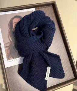Close-up detail of a soft dark blue ribbed knit winter neck warmer scarf on a tray.
