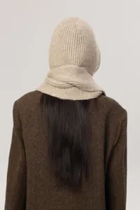 Back detail view of beige knitted balaclava hood and scarf combo with stylish brown coat.