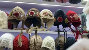 Häkelblumen Mütze Detailansicht mit handgefertigtem Strickdesign und Fransen Quasten.