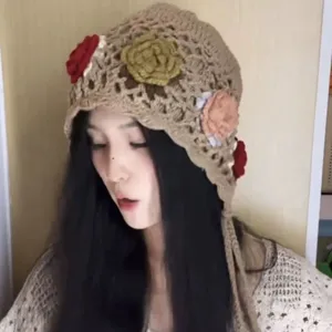 Handgemachte Häkelmütze mit bunten Blumenapplikationen und Quasten für Damen im Ethno-Stil.