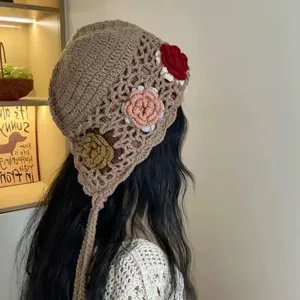 Handgemachte Häkelmütze mit Blumen und langen Quasten für Damen im gemütlichen Ethnostil.