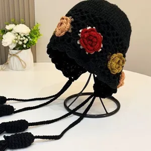 Handgefertigter Häkel-Blumen-Hut mit bunten Blüten und langen Quasten, Ethno-Stil.