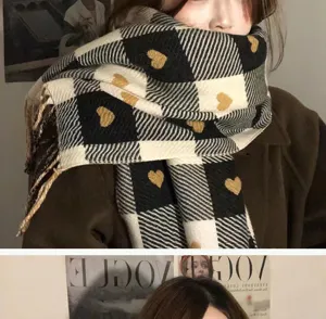 Detailed close-up of cozy black and white plaid winter scarf featuring cute gold heart patterns.