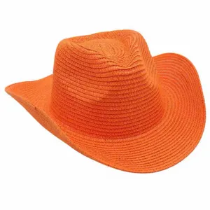 Detalle sombrero de paja naranja, textura ala curvada primer plano, protección sola playa verano.
