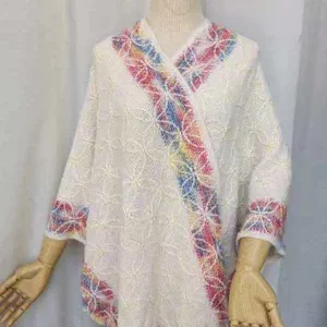 Poncho mantella in maglia boho con bordo colorato, ideale per viaggio primavera estate.
