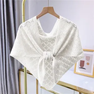 Hollow-out knit shawl detail showing the fine mesh texture and front tie knot design.