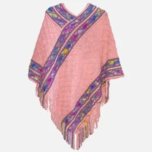Pink knit poncho with colorful woven stripes and fringe hem, cozy outer wear for travel.