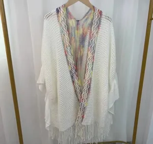 Détail de châle en tricot ajouré blanc, col à rayures colorées et finitions à franges.