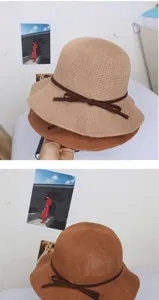 Detailansicht des gestrickten Strohhutes mit eleganter brauner Schleife, Sonnenschutz.