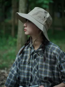 Detailed shot of outdoor bucket hat in khaki, featuring adjustable chin strap and eyelets.