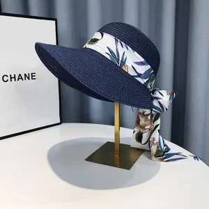 Nahaufnahme des blauen Damensonnenhuts mit eleganter Seidenschleife und Blumenmuster.