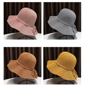 Detailed view of the knit sun hat, showing delicate woven texture, wide brim, and cute side bow.