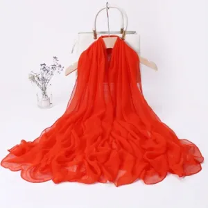 Detailed shot of a vibrant red long chiffon scarf, lightweight and elegant for wear.