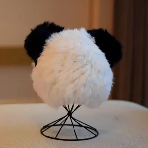 Detailed view of the cute plush panda winter hat, featuring fluffy black and white ears.
