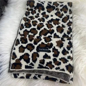 Detailed view of stylish leopard print knitted winter scarf showcasing soft texture and warm fabric.