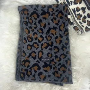 Leopard print knitted scarf detail showing soft wool texture and elegant winter pattern design.