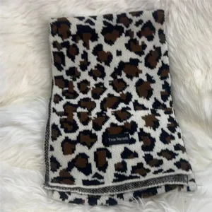 Detailed close-up shot of a cozy women winter leopard print knit scarf texture.