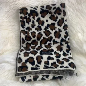 Close up detail of a stylish leopard print knit scarf, soft winter warm fashion accessory.