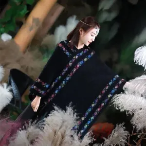 Cozy black geometric patterned knitted poncho, elegant outdoor travel photography shawl cape apparel.