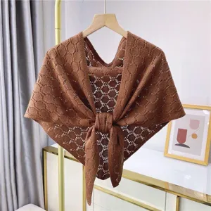 Detailed view of women brown hollow-out knitted shawl draped triangular scarf for office wear.