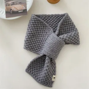 Winter knitted cross scarf for women, cozy grey neck warmer and stylish cold weather gear.