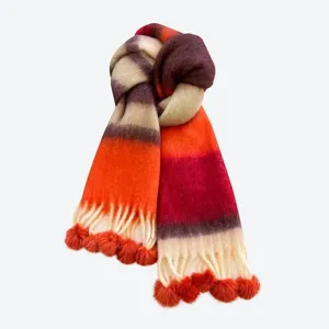 Detailed view of the colorful gradient mohair scarf with tassels and cute pom pom accents.