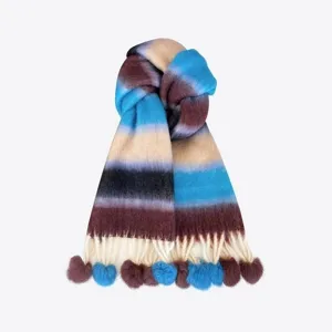 Detail shot of colorful gradient mohair scarf featuring playful pom poms and warm fringe design.