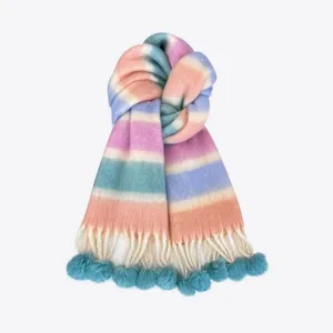 Detailed view of a pastel rainbow gradient mohair scarf with cozy tassels and cute pom poms.