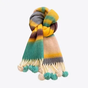 Close-up detail of the colorful gradient mohair scarf featuring playful tassels and fluffy pom-poms.