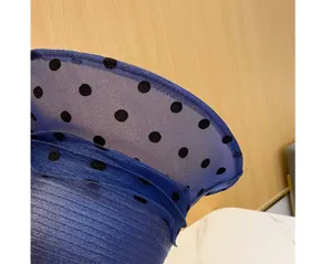 Primo piano dettaglio cappello sole donna organza blu pois neri design elegante traspirante.